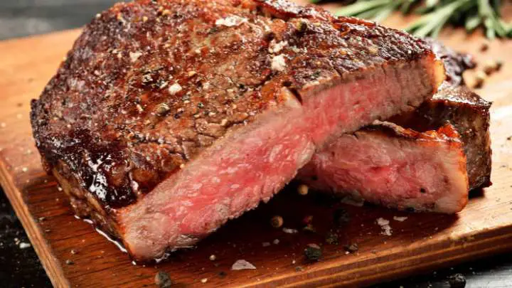 medium rare steak on a wooden board - millenora